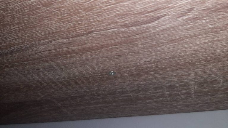 Screw at the bottom of a floating shelf